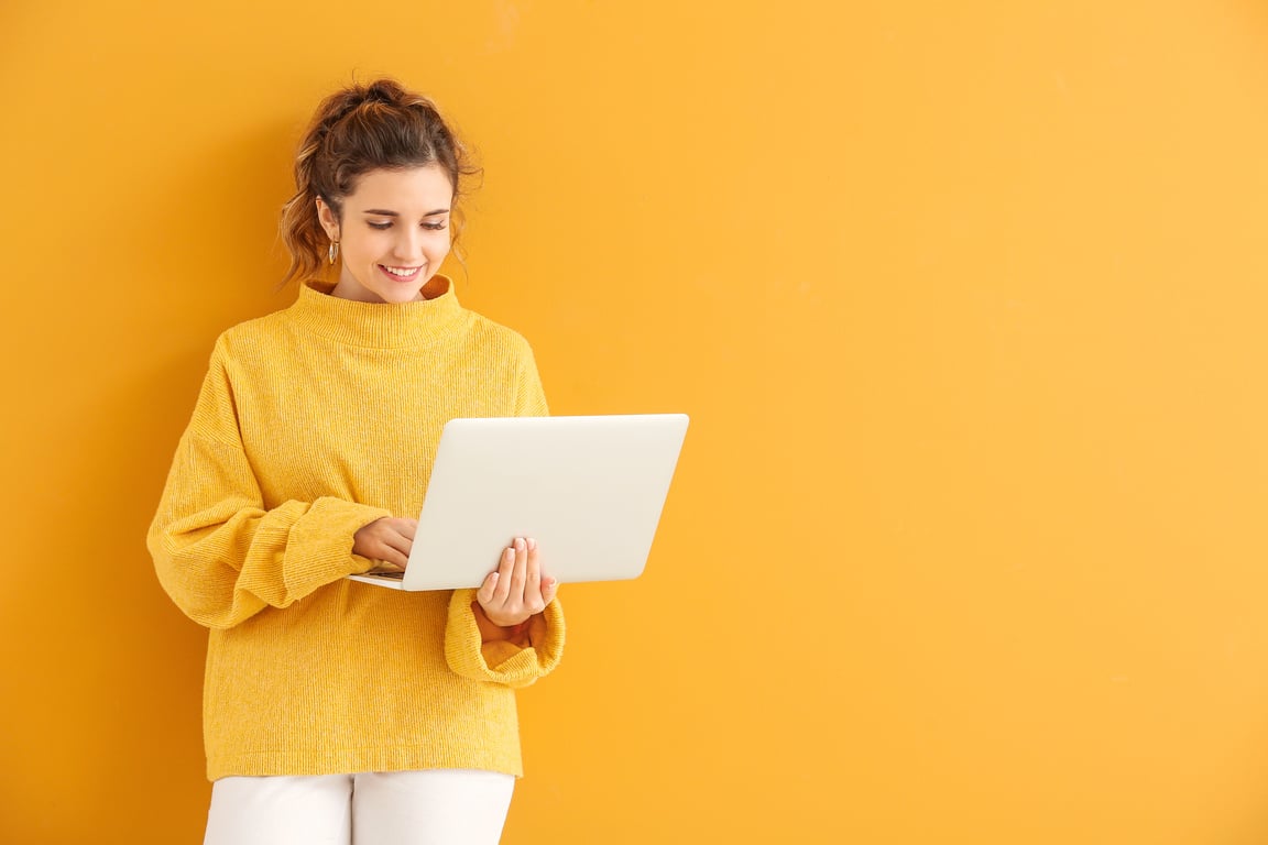 Beautiful Young Woman in Warm Sweater and with Laptop